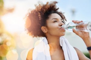 Mulher bebendo água | Mantenha a pele hidratada